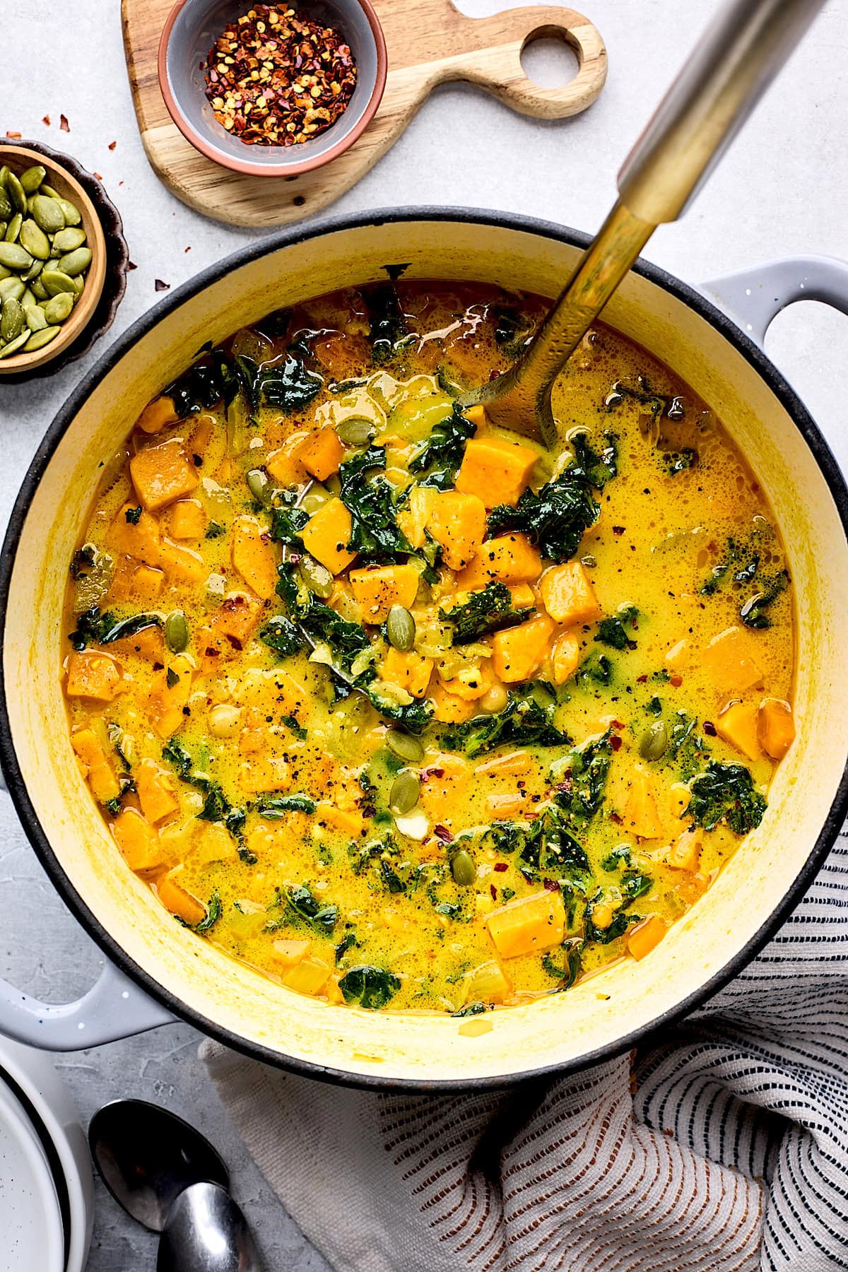 Creamy Coconut Ginger Sweet Potato Soup in pot with ladle.