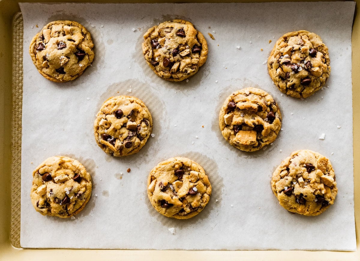 graham cracker toffee chocolate chip cookies on baking sheet with parchment paper.