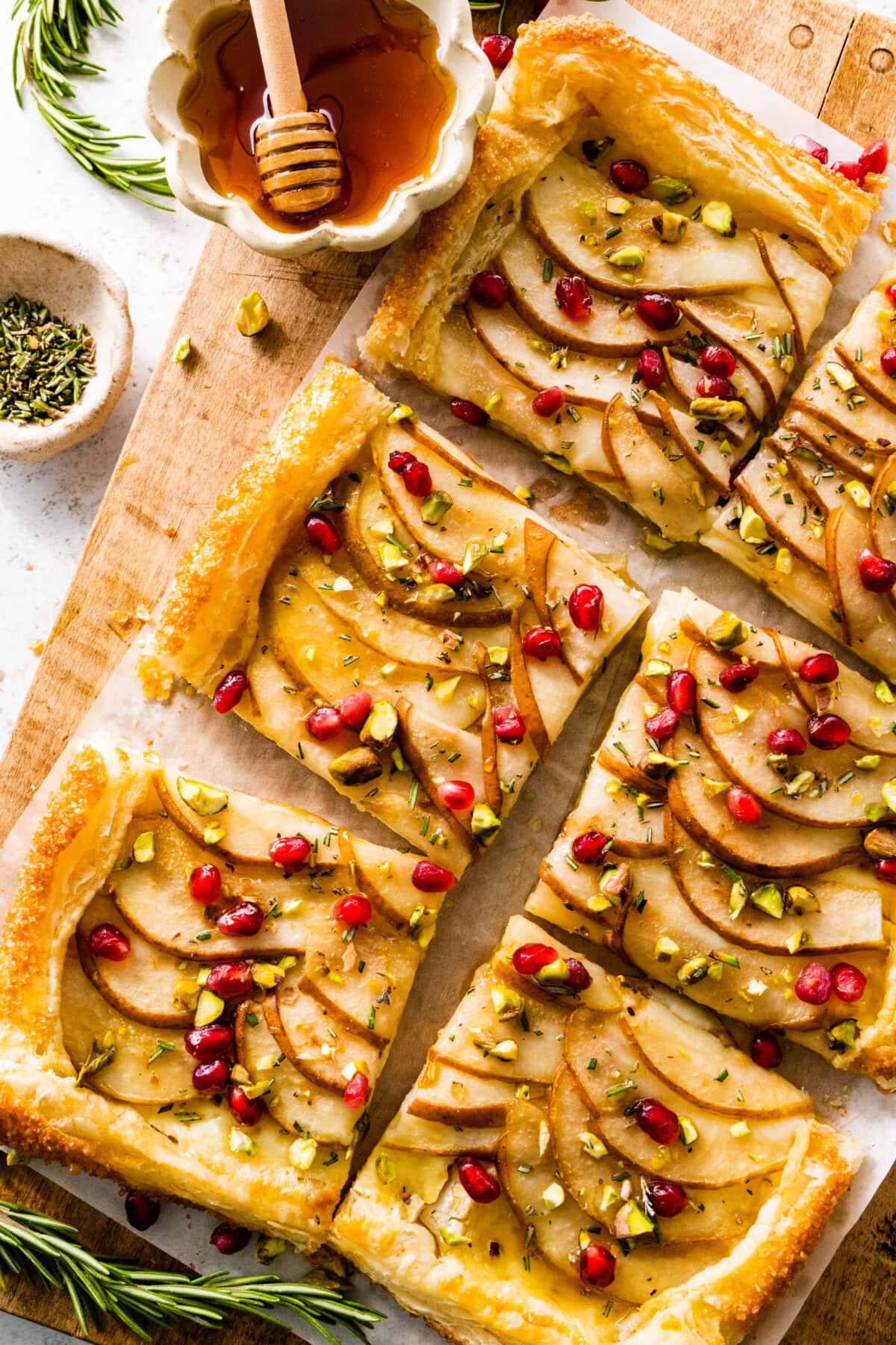 pear brie puff pastry tart with pomegrante, pistachio, rosemary, and honey.