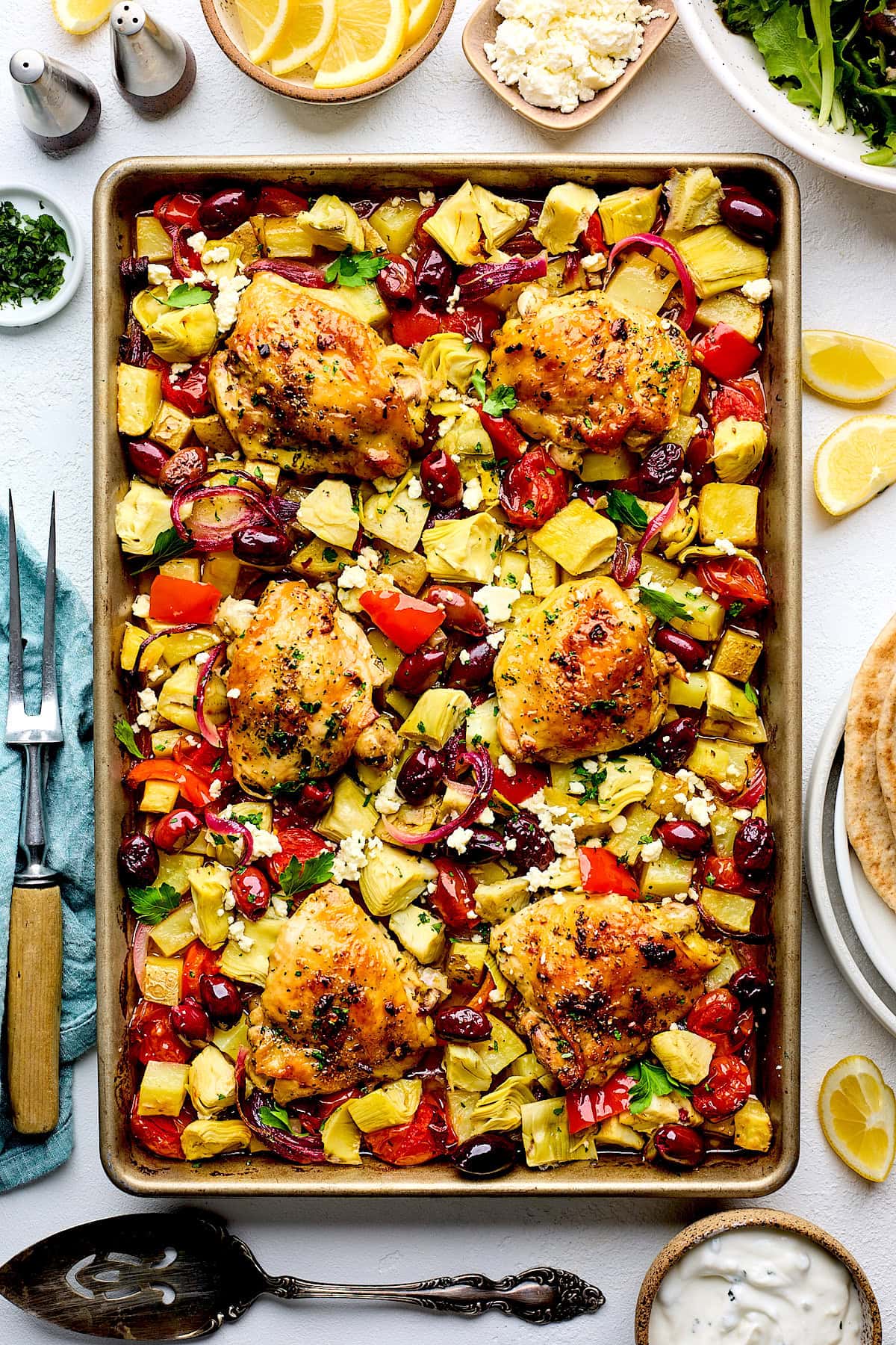 Greek sheet pan chicken with artichokes, potatoes, tomatoes, peppers, red onion, kalamata olives, feta, and herbs.