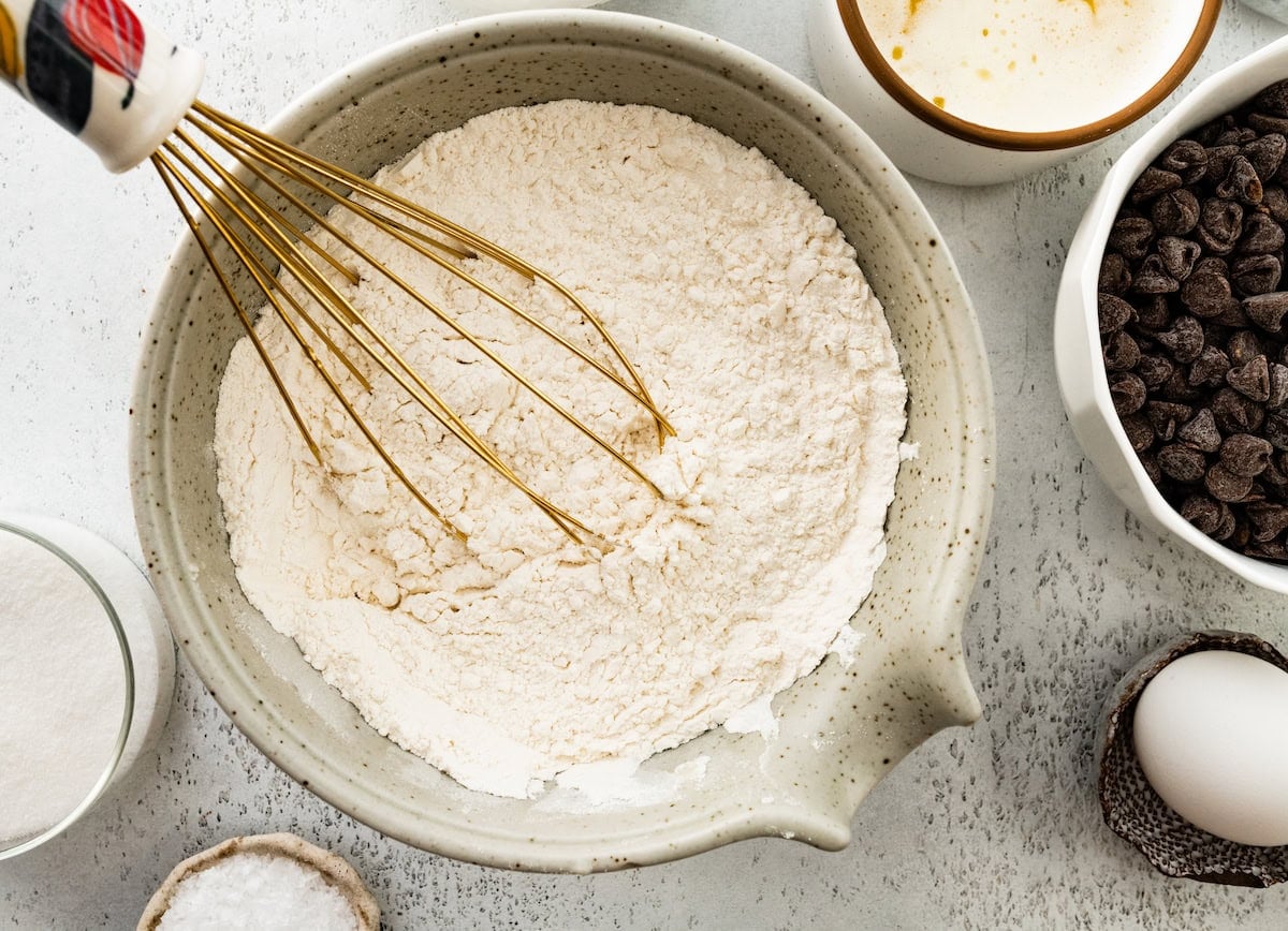 dry ingredients being whisked together in a bowl.