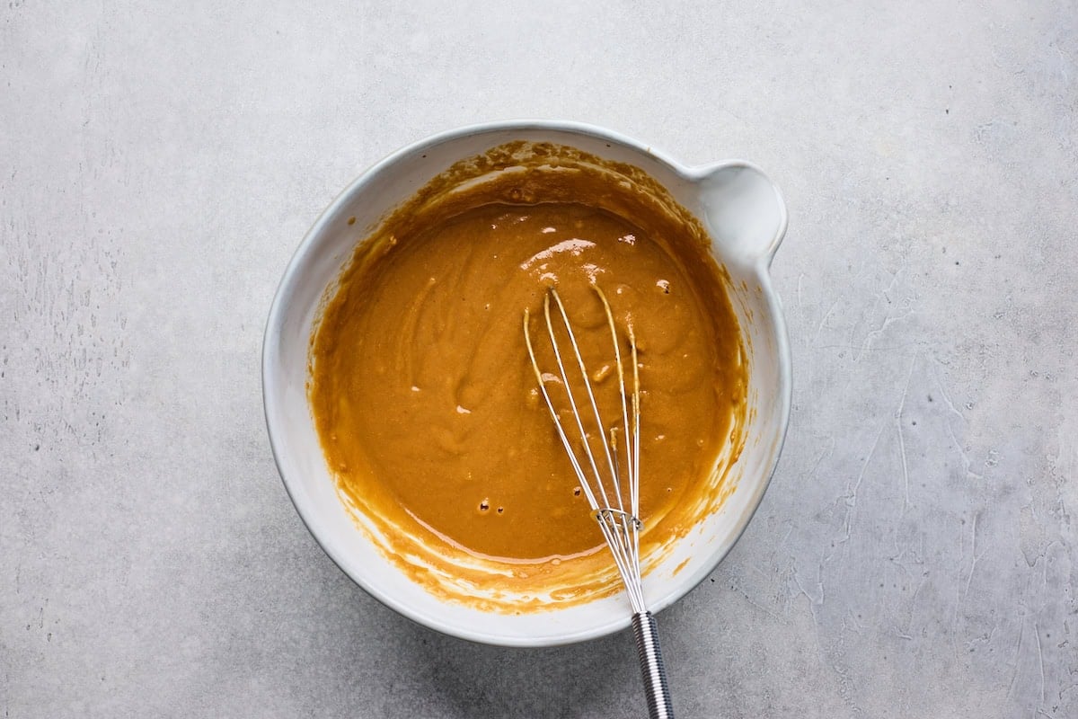 peanut sauce in bowl with whisk.