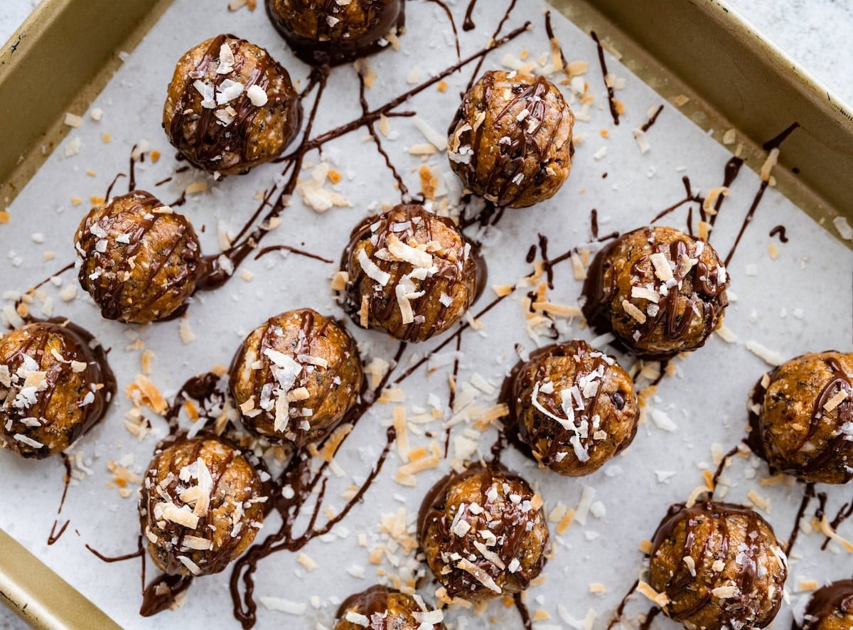samoa cookie protein balls dipped in chocolate with toasted coconut and a drizzle of melted chocolate.