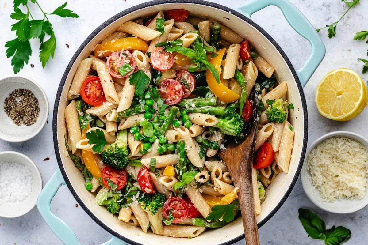 pasta primavera in pot with wooden spoon.