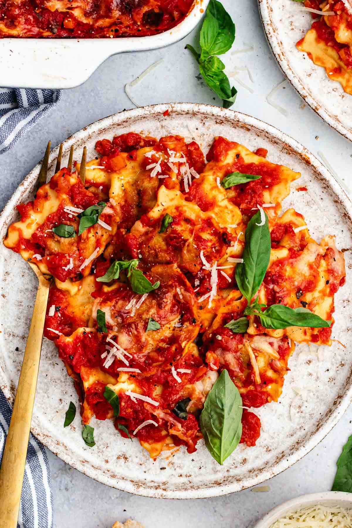 ravioli lasagna on plate with fresh basil and fork. 