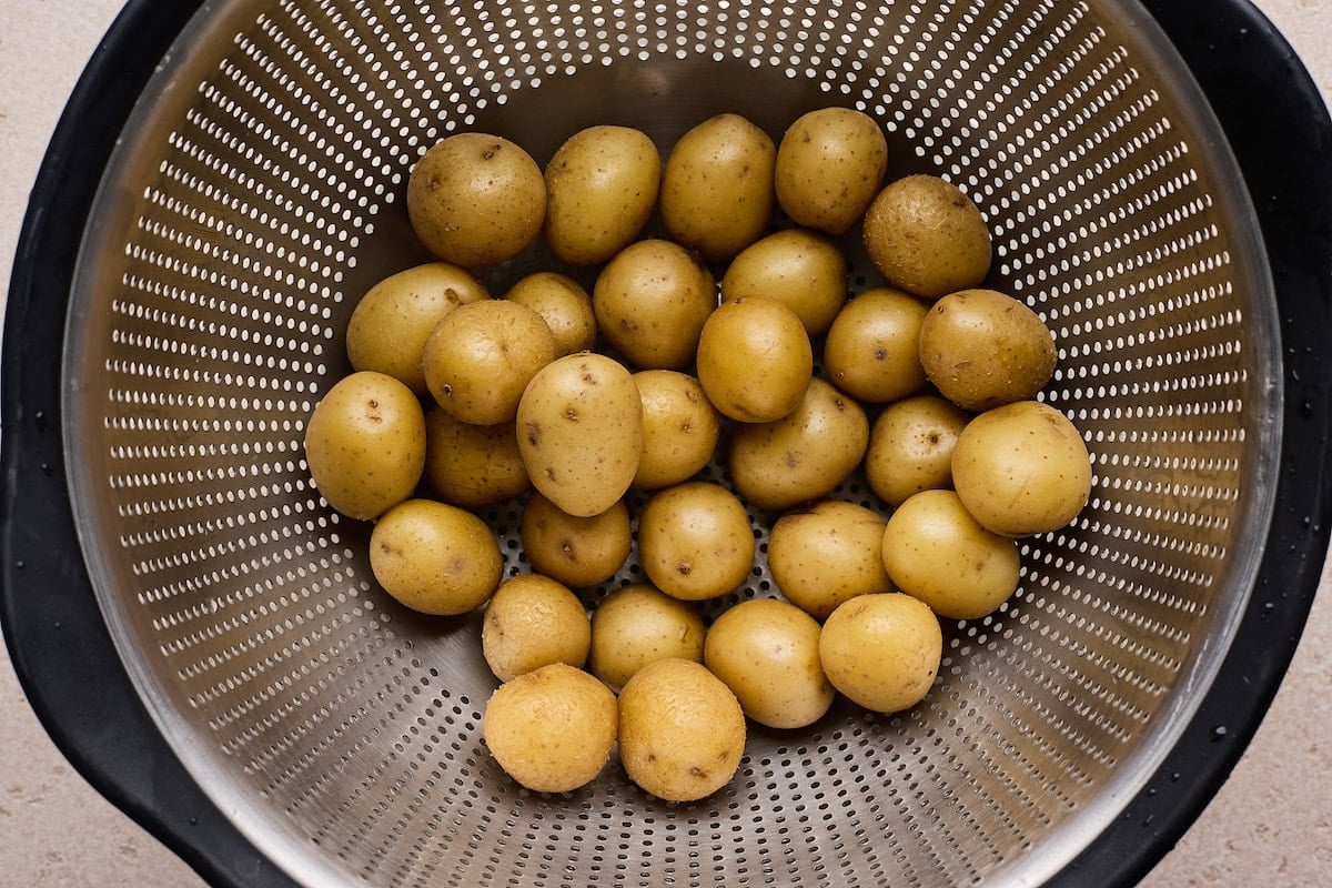 cooked baby Yukon gold potatoes in strainer.