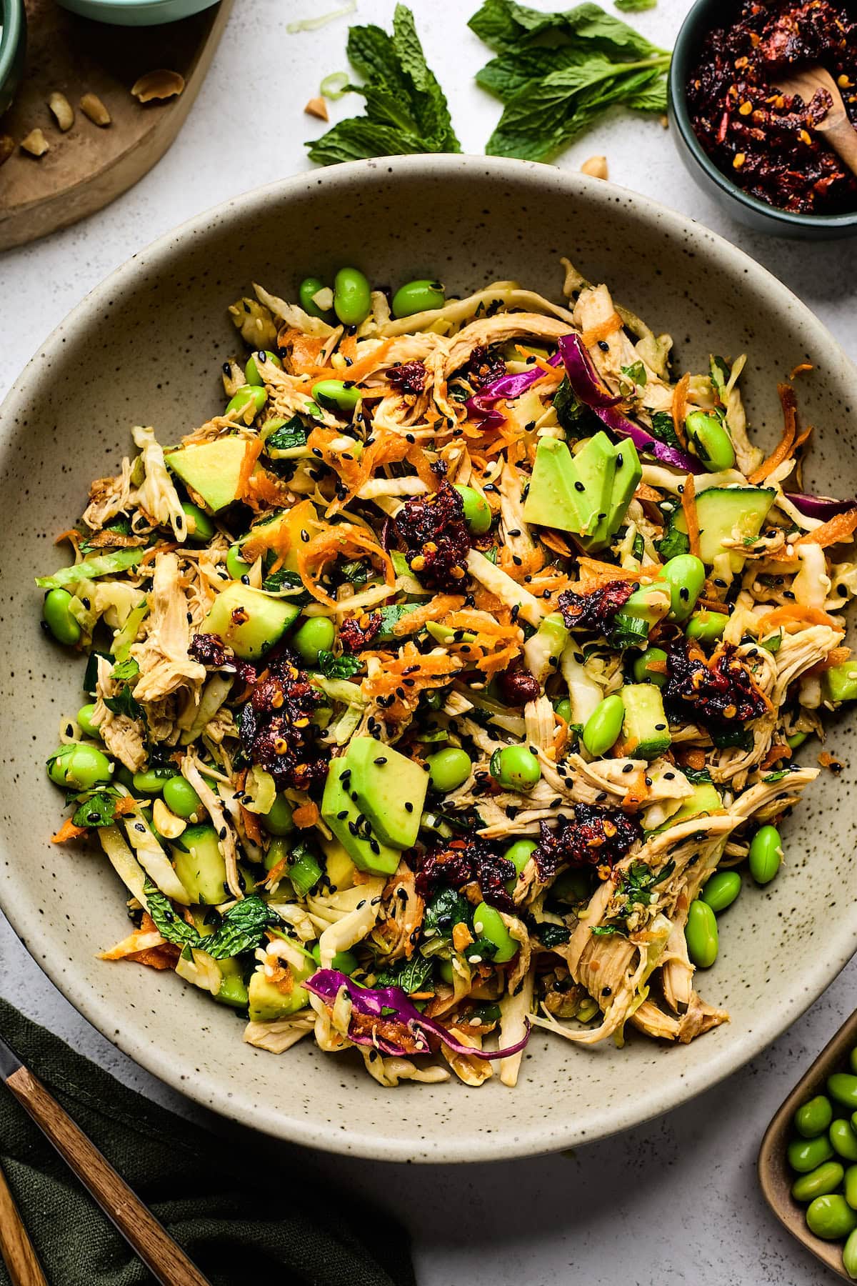 Asian chicken salad with chili crunch in bowl.