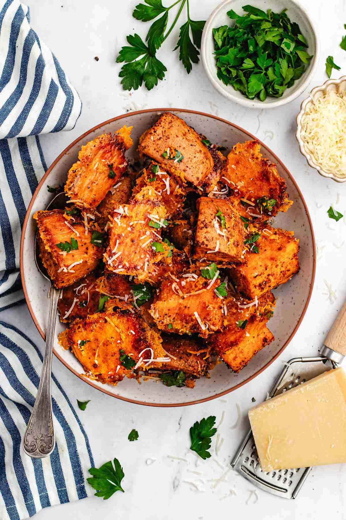 crispy parmesan sweet potatoes in bowl. 