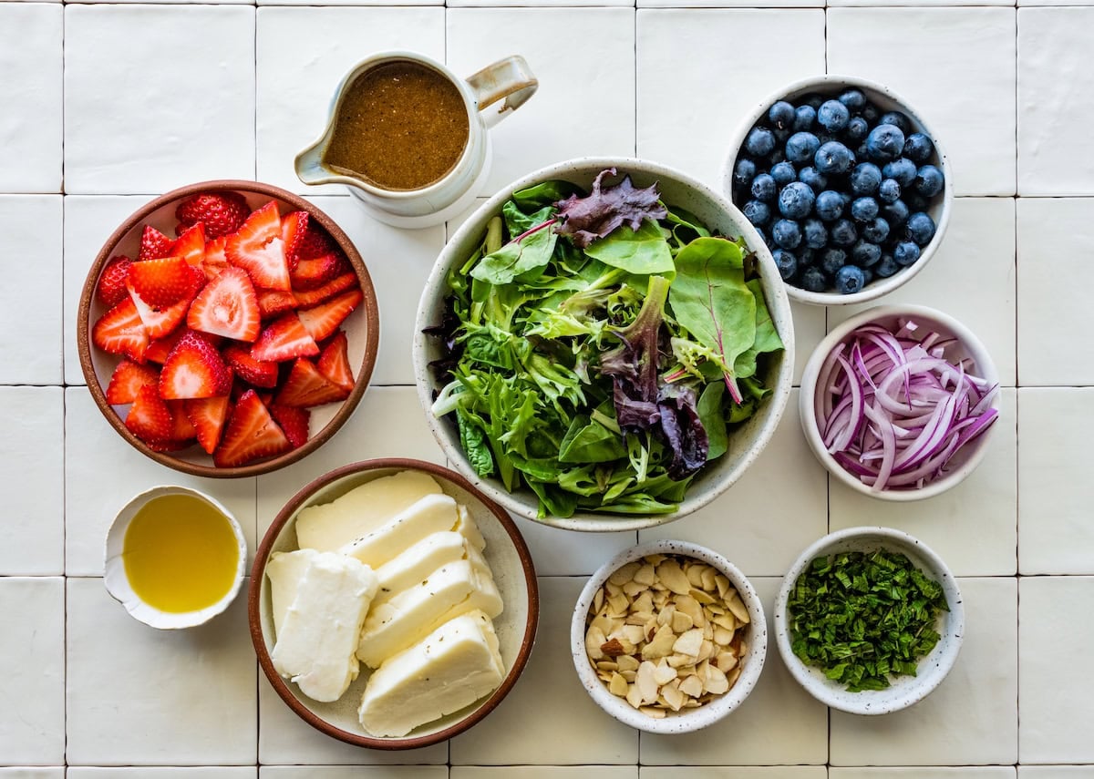 ingredients in bowls to make grilled halloumi berry salad.