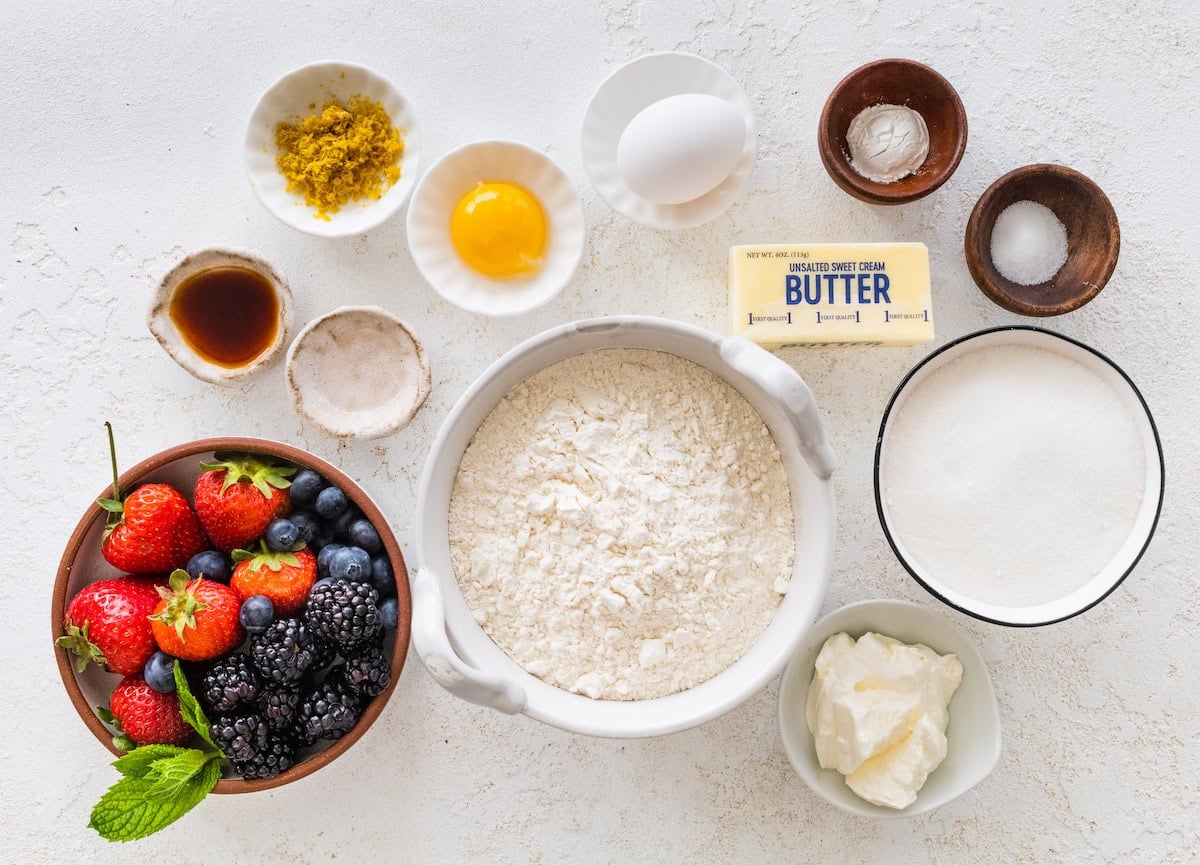 sugar cookie fruit pizza bar ingredients in bowls.