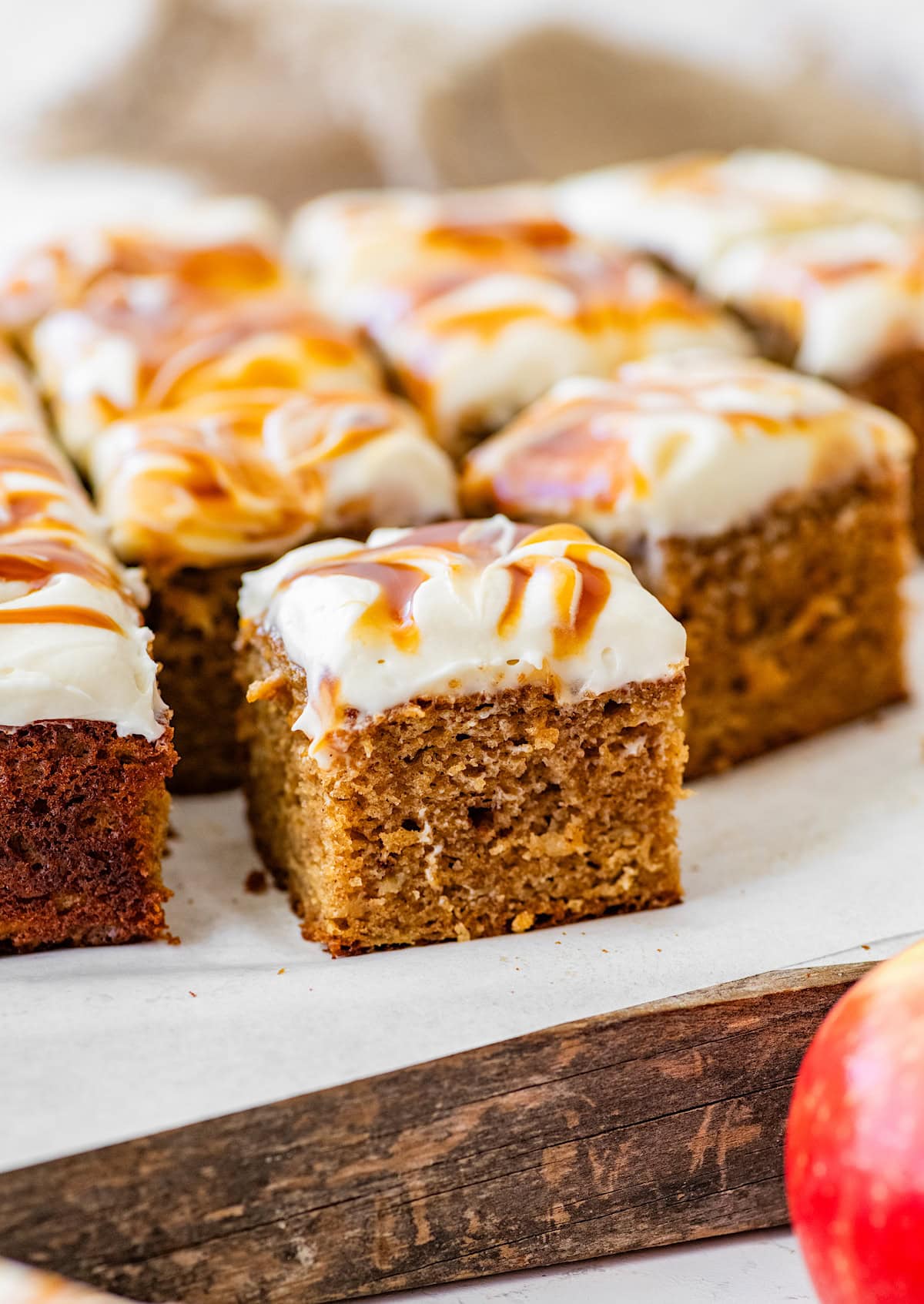 close up of piece of apple spice cake with salted caramel cream cheese frosting.