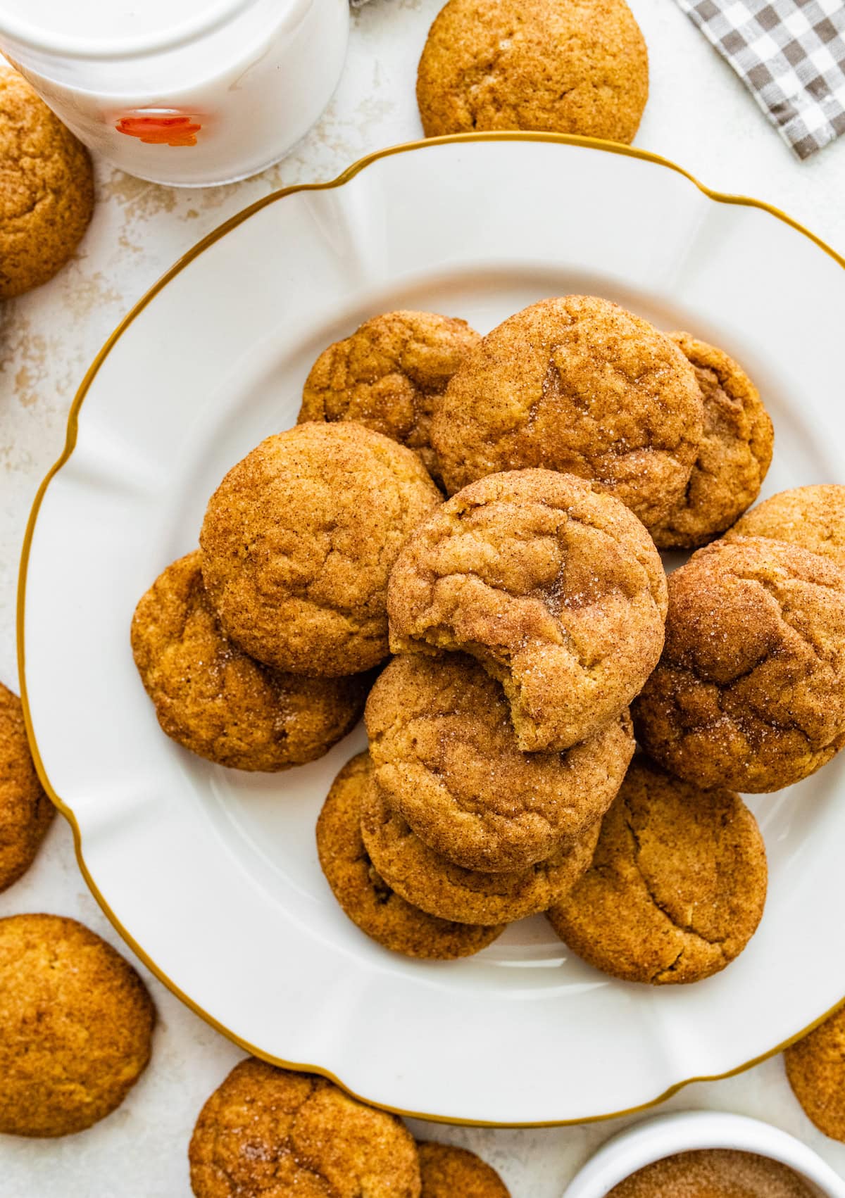 pumpkin snickerdoodles on plate with glass of milk. 