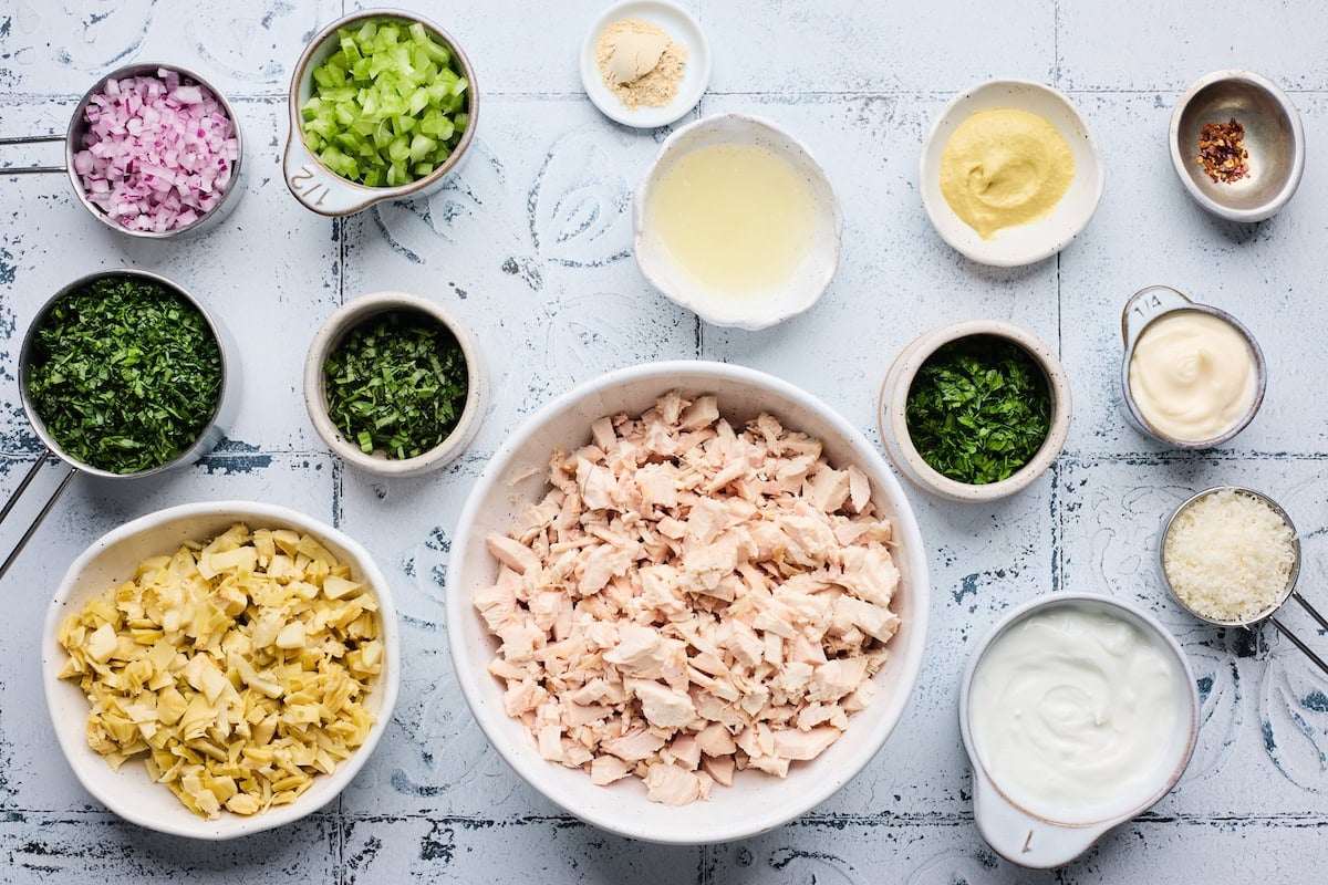 ingredients in bowls to make spinach artichoke chicken salad.