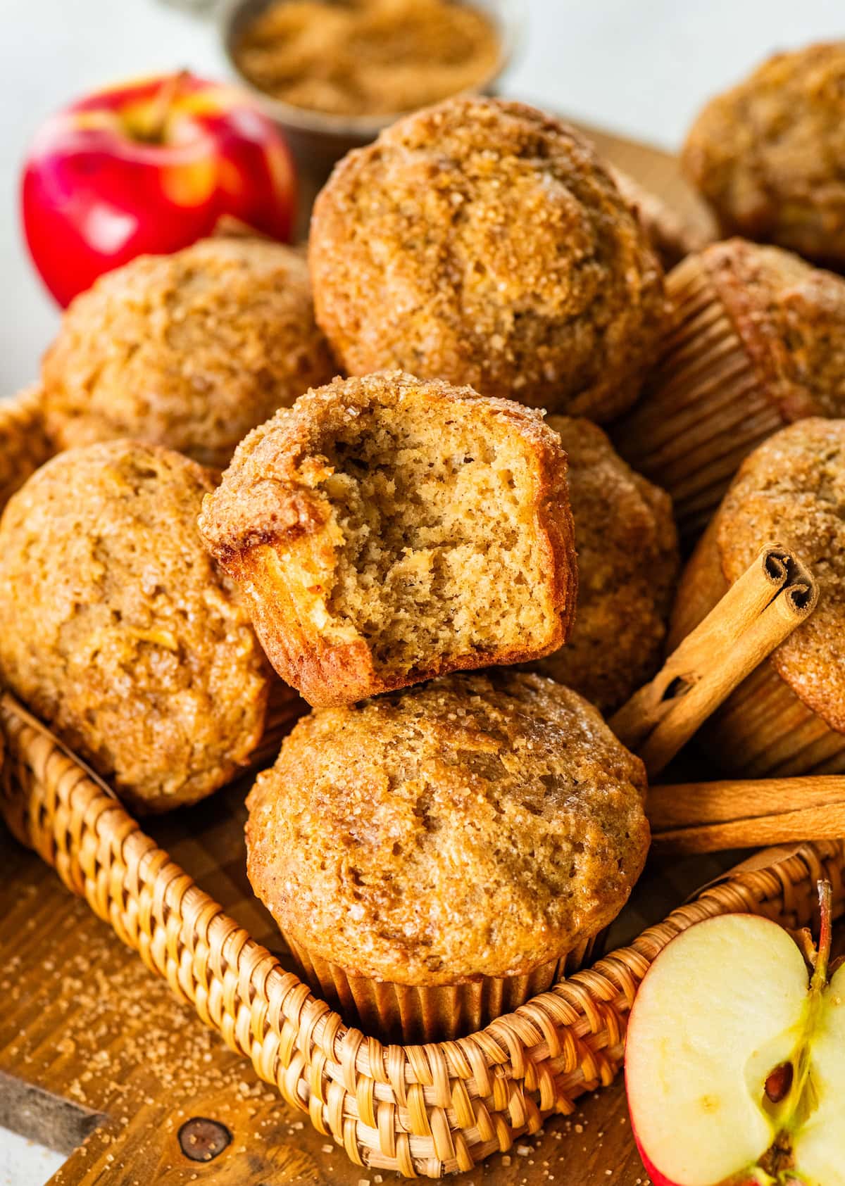 healthy apple muffins in basket with a bite out of one muffin.