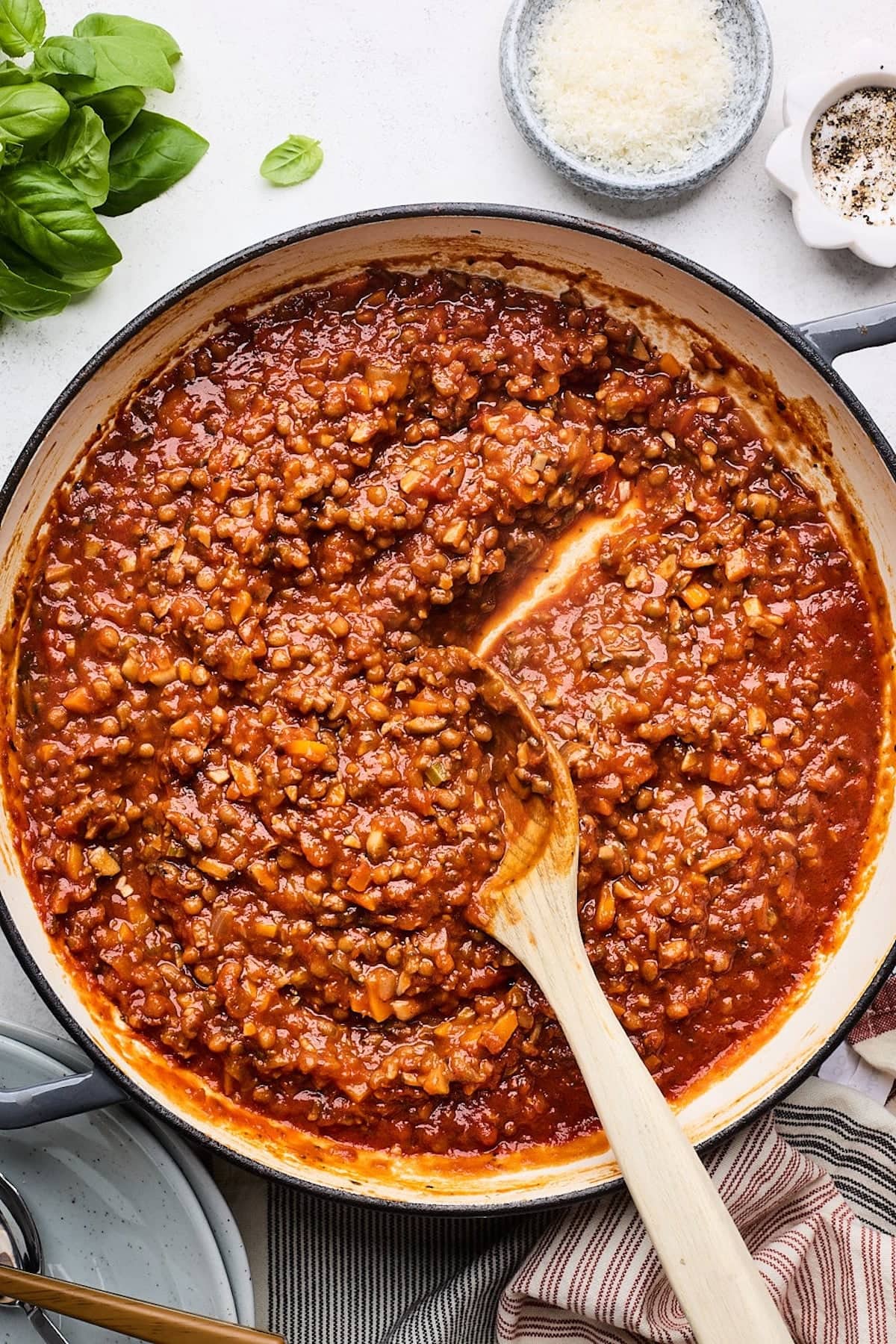 lentil bolognese in pan with wooden spoon.
