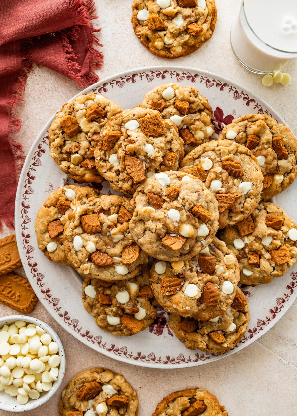 Brown Butter Oatmeal Biscoff Cookies with Toffee & White Chocolate on plate with glass of milk.