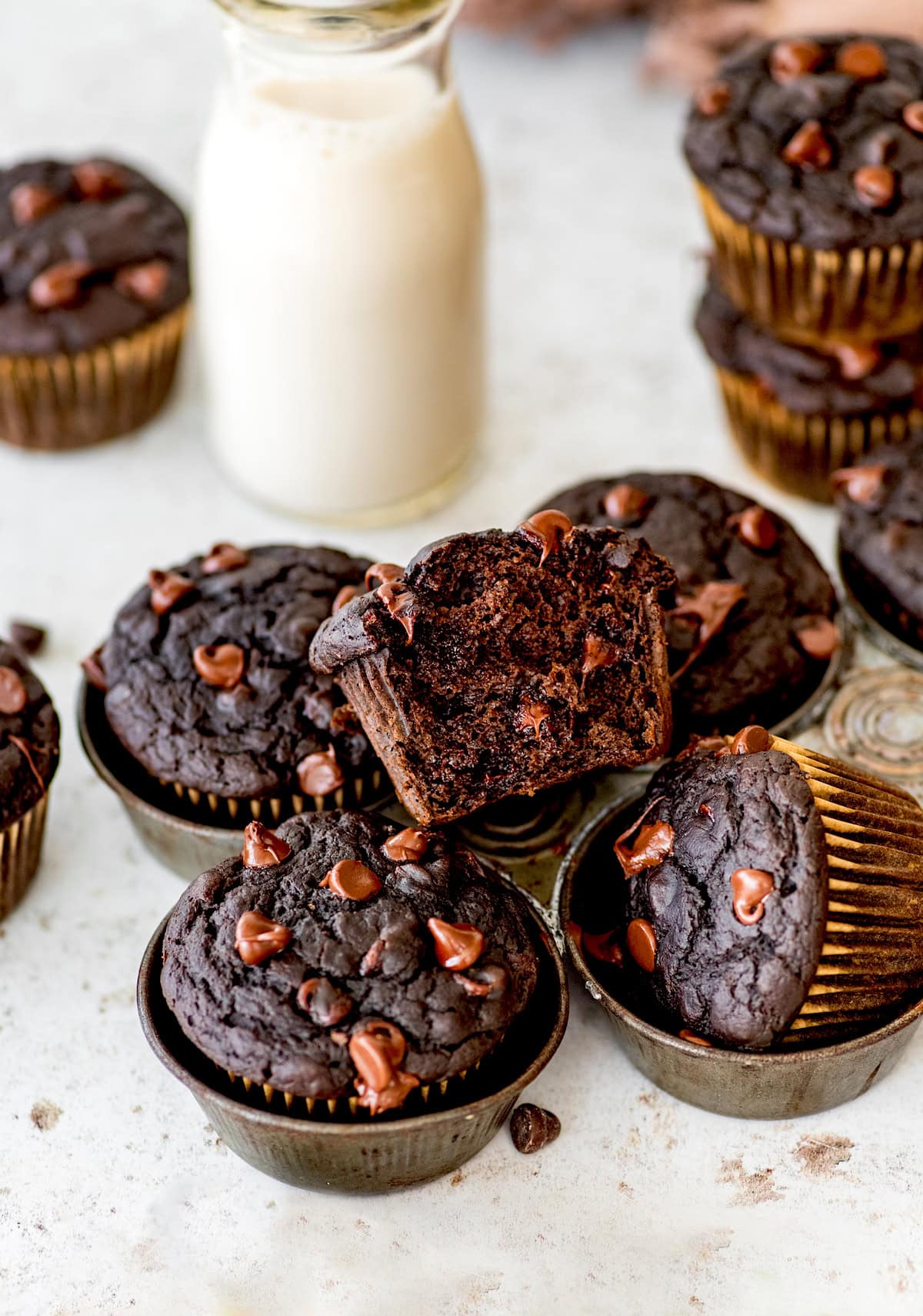 healthy chocolate vegetable muffins with chocolate chips on top and glass bottle of milk.